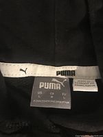 Close-up photo of the Puma brand label inside the hoodie showing size large and made in Bangladesh.