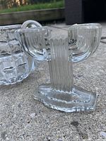 Art Deco style glass candlestick with ribbed vertical column and stepped base, rounded candle arms