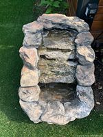 Top-down view of the fiberglass water fountain showing textured rock-like tiers and water basin