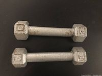 Photo showing a pair of metal 3-pound hex dumbbells with some surface wear.
