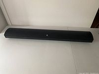 Front view of the black soundbar speaker on a table.