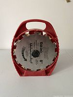 Front view of red plastic case holding 8 inch Dado stack router cutter blades with label and metal teeth visible.