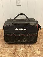 Front view of Husky tool bag showing five external pockets and top handles.