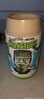 Front view of the cream-colored plastic thermos depicting Frankenstein's Monster with detailed colored graphics.