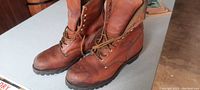 View of the pair of brown leather heavy duty boots showing side profile and treaded soles.