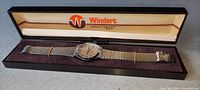 Vintage men's wristwatch inside its original Windert branded plastic snap lid case, shown closed