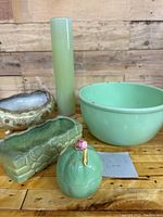 Photo of jadeite mixing bowl with accompanying lime green pottery, porcelain, and glass items grouped on wooden surface