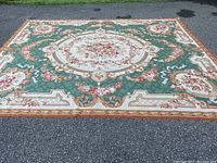 Full view of entire rug laid out on driveway showing overall design and color palette.