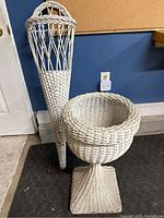 Full view of both white wicker items showing plant stand and cone planter side by side
