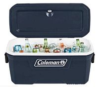 Blue Coleman 316 Series hard chest cooler with lid open, showing interior filled with various beverage cans and bottles chilled with ice.