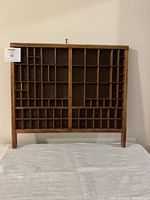 Full front view of the wooden letterpress tray showing the grid compartments and overall shape.