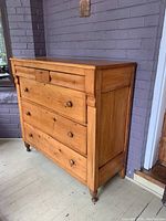 Front and side angle view of dresser showing turned bun feet and wood finish