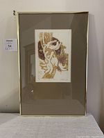Framed folk art watercolour artwork with a gold metal frame on a wall.