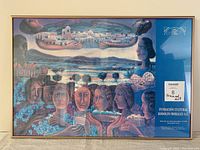 Framed colorful print by Rodolfo Morales showing faces and cultural landscape imagery under glass in a thin wooden frame.