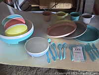 Photo showing assortment of vintage Bolero thermal ware bowls, plates, mugs, and flatware in pastel colors arranged on table.