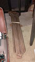 Side view of the folded wooden drying rack showing the overall size and shape, with metal rivets visible in joints.