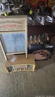 Photo showing vintage Emerson radio with yellow casing, National 510 washboard, and hors d'oeuvres tray with utensil graphics boxed.