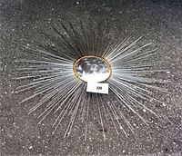 Full view of the sun wall art showing the metal rods radiating around the hammered center