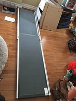 Full length adjustable pet ramp with non-slip dark gray surface and metallic frame showing.