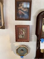 Four framed wall art pieces displayed on wall; includes various portraits and decorative prints.