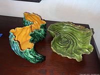 Two hand formed ceramics: a bowl and a vase on a wooden surface, showing green and yellow glaze.