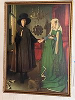 Full view of framed Arnolfini Portrait print showing man and woman holding hands with visible frame edges.