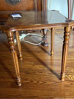 Side view showing turned legs with carved grooves and rounded feet.