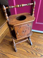 Front and side view of vintage hardwood smoker stand with cabinet door, circular hole on top, and handle.