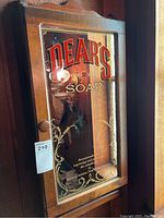 Photo of vintage wooden wall cabinet with mirrored door showing DEAR'S SOAP in red and gold painted lettering.