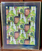Framed print showing stylized parrots and lanterns in a repeating geometric pattern in green, orange, and blue tones.