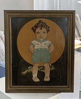 Front view of the vintage oil painting depicting a child in green shorts and white shirt with a large circular ochre backdrop.