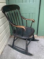 Side view showing curved armrest, spindle back and rocker base