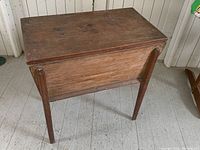 Front view of box on legs showing rectangular lid and leg design