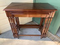 Four mahogany nesting tables stacked together