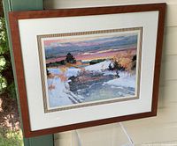 Full view of the large framed art print featuring a snowy winter scene with trees and a colorful sunset sky.