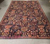 Full view of carpet, showing overall floral pattern on dark background