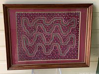 Framed large vintage Mola textile art with vibrant patterned fabric inside a wooden frame.
