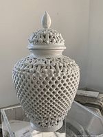 Full view of the 10-inch white porcelain reticulated vase with a pierced lid and flame finial, displaying the intricate latticework details.