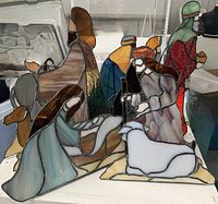 Group photo of nativity scene stained glass figures including Mary holding baby Jesus, Joseph, the three wise men, donkey and sheep arranged together