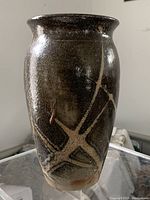 Front view of pottery vase emphasizes shape and abstract surface decoration.