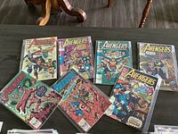 Set of 7 Avengers comic books laid out for display, showing colorful covers from the early 300s series featuring Marvel superheroes in action.