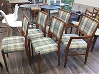 Group photo displaying all five teak chairs arranged in a cluster showing front and side views