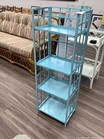Full view of blue painted metal shelf with 4 tiers showing overall condition and design.