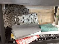 Shelf with woven placemat, table runner, wooden tray, and mosaic tiled tray