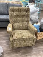 Front view of the fabric upholstered rocker recliner chair with textured beige and brown fabric and padded armrests.