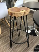 Side view of the live edge wood bar stool showing the wooden seat with natural grain on a metal base.