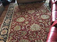 Full view of the red central field of the rug showing floral and paisley motifs.