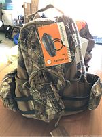 Camouflage hydration pack with tags attached showing Liquifusion hydration bladder box and camo pattern
