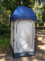 Front view of the closed camp privy tent with zippered door and solid fabric roof