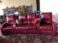 Front view of full three-seat sofa showing red leather upholstery and cup holders